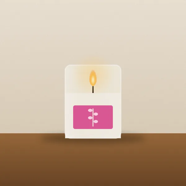 A candle in a clear jar with a pink label and a stem of fireweed