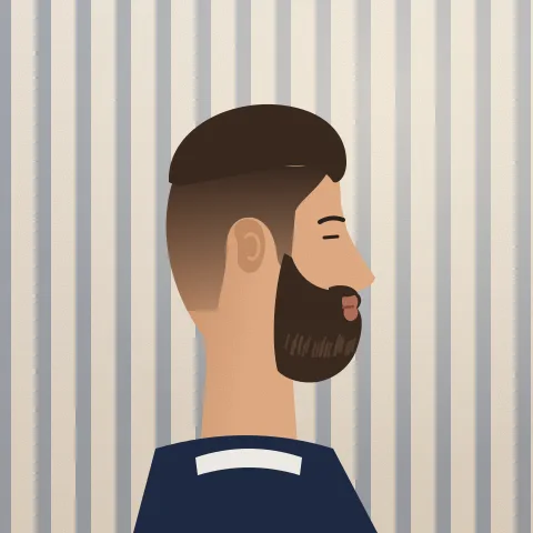 A man side on with a full, squared-off beard and a sharp cheek line