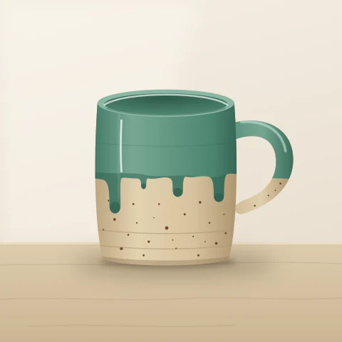 A speckled stoneware mug with a green glaze dripping from the rim