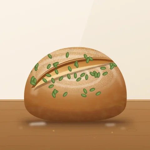 A round loaf with green pumpkin seeds pressed into its crust